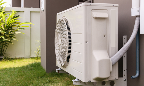 Unidad exterior de aerotermia con conducto aislante instalada en un jardín de Barcelona