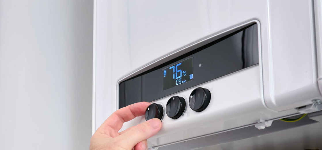 Técnico ajustando la temperatura de una caldera en su panel digital durante una reparación en Barcelona
