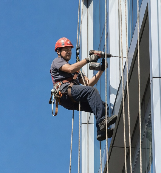 Técnico especializado en trabajos verticales interviniendo en una fachada de difícil acceso en Barcelona